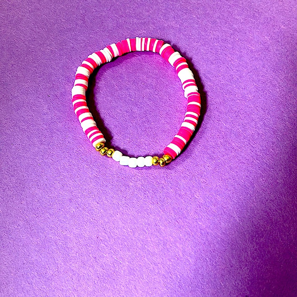 Homemade bracelet.Hot pink and white bracelet with white and gold plastic beads.
